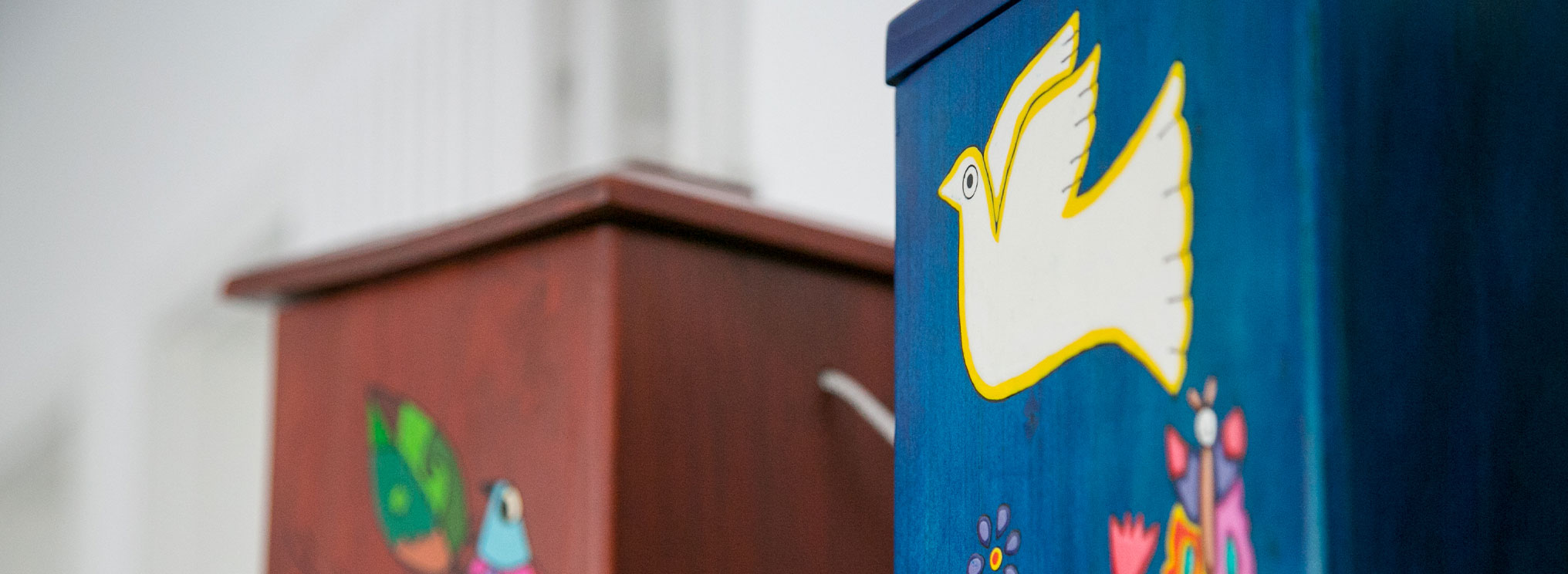 Eine kunstvoll verzierte Holzurne mit Friedenstauben-Motiv.